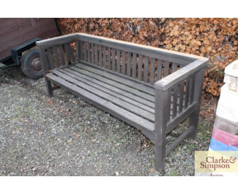 A three seater teak garden bench, in need of repair