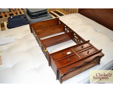 A mahogany hanging wall shelf fitted four drawers