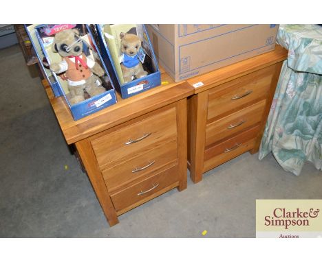 A pair of modern light wood three drawer bedside chests