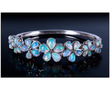 Opal Flower Bangle, seven graduated flowers, each one comprising five pear cut opal cabochons, totalling 6.5cts, the largest 