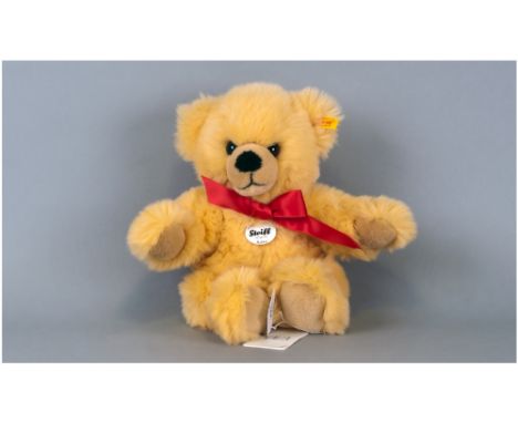 Steiff Bear 'Bobby' yellow fur with red bow. Steiff button to ear with label & booklet still attached.