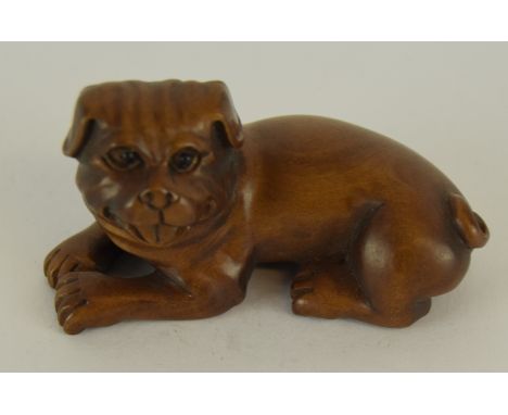 a Japanese carved wooden netsuke in the form of a dog signed to the base