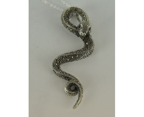 an unusual silver snake pendant necklace with ruby eyes