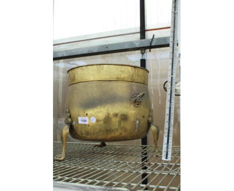 A VINTAGE BRASS COAL BUCKET WITH LION PAW HEAT AND LION HEAD HANDLES 