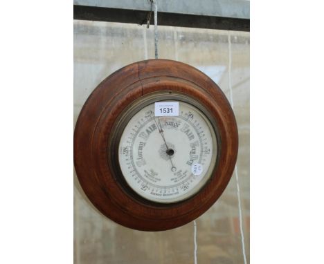 A CIRCULAR VINTAGE OAK CASED BAROMETER 