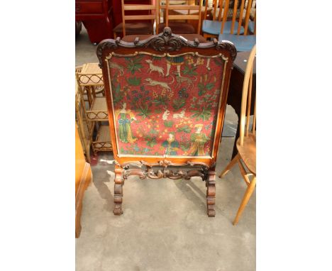 A VICTORIAN ROSEWOOD FIRESCREEN WITH GILT DECORATION, SCROLL LEGS AND STRETCHER AND FOLIATE CARVER TOP RAIL WITH WOOLWORK PAN