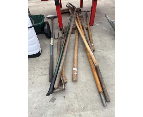AN ASSORTMENT OF GARDEN TOOLS TO INCLUDE AN AXE, RAKES AND A FORK ETC