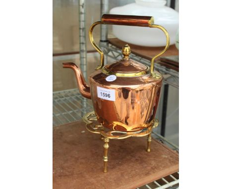 A VINTAGE COPPER KETTLE WITH A BRASS TRIVET STAND DEPICTING A PEACOCK 