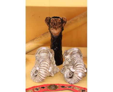 A PAIR OF WALL MOUNTABLE ELEPHANT HEAD PLANTER/ STORAGE JARS TOGETHER WITH A CERAMIC CHIMPANZEE HEAD JAR/VASE 