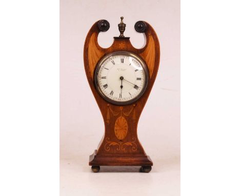 An Edwardian mahogany and boxwood inlaid mantel clock, the case with broken arch pediment, surmounted by brass finial, the en