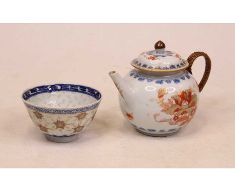 An 18th century porcelain teapot and cover, of bullet shape, having floral decoration in shades of iron-red and gilt, with ra