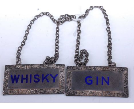 A pair of silver decanter collars annotated in blue enamel for Gin and Whisky, maker T&amp;S Birmingham 1938/9, width 5cm, 48