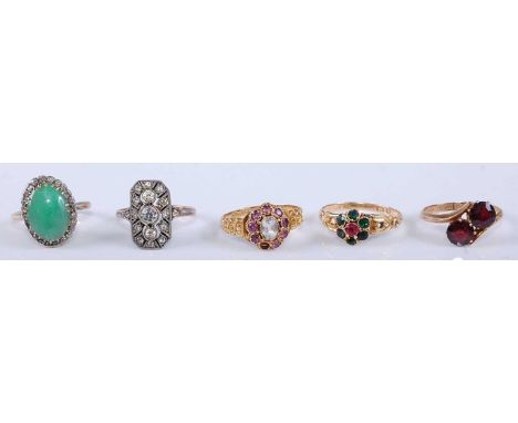 A 9ct gold garnet set crossover ring, a 15ct gold zircon and amethyst set ring, a 15ct gold ruby and green tourmaline set dre