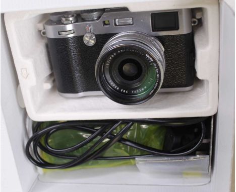A Fuji Film X100F digital camera, battery, charger, manual and cables