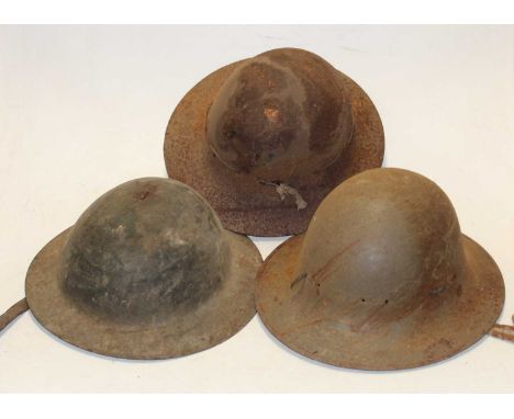 A WW II Zuckerman steel helmet, together with one other and a Brodie pattern helmet. (3)