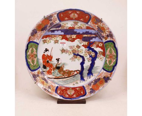 A large Japanese Meiji period (1868-1912) charger of circular form, the centre enamel decorated with two female figures withi