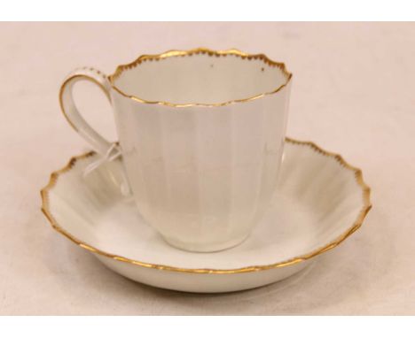 A late 18th/early 19th century Worcester porcelain teacup and saucer of fluted form on a white ground with gilt decoration ha