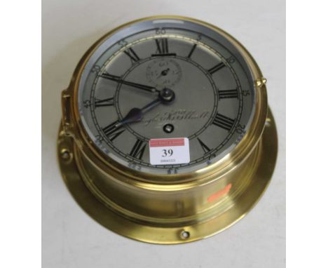 A brass cased ships clock, the circular silvered dial with Roman numerals, Arabic outer numerals and subsidiary seconds dial,