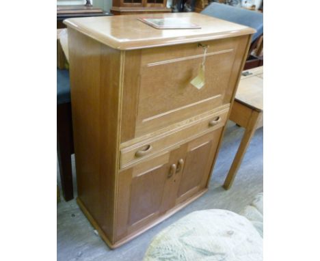 A mid 20thC oak Ercol design cocktail cabinet, having a fall front, over a drawer and twin doors, on a plinth    43''h  32''w