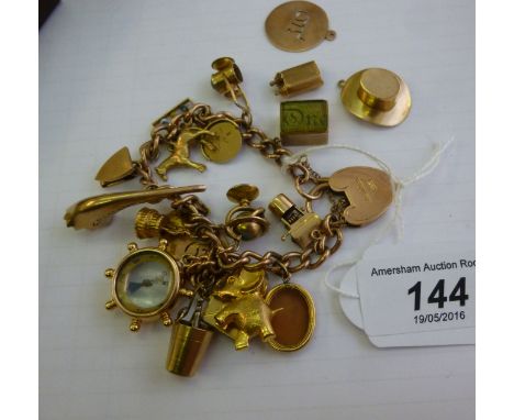 A 9ct gold charm bracelet with various charms: to include a ships wheel compass         11