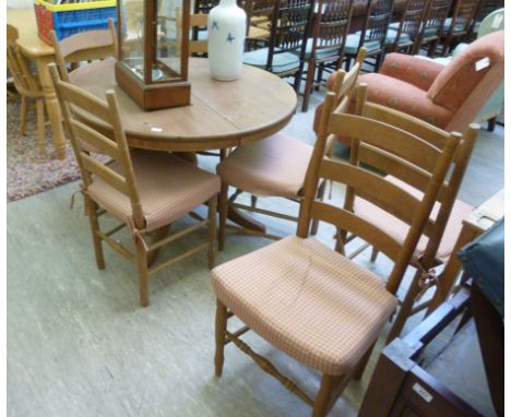 A modern pine extending kitchen table, having a turned column, raised on splayed legs  30''h  42''dia extending to 60''L with