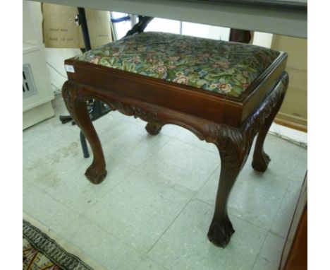 A 1930s mahogany finished stool, the drop-in, floral tapestry upholstered top raised on cabriole legs, talon and ball feet wi
