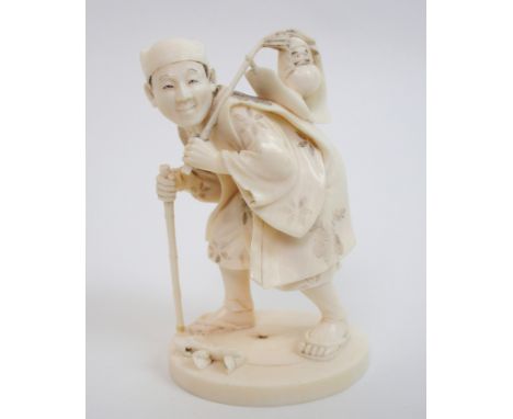 A Japanese carved ivory okimono of a man hunched over holding a stick and carrying gifts on his shoulder (signature lacking f