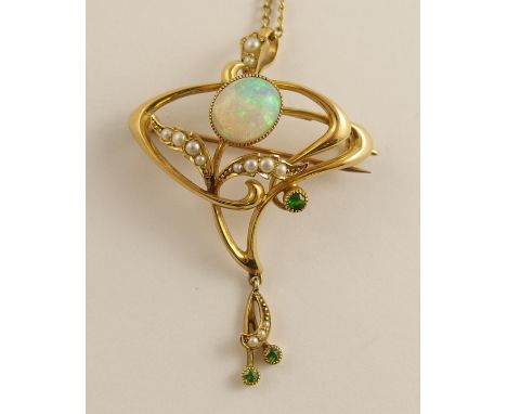 A 15ct gold Art Nouveau opal pendant brooch of classic whip lash design further set with split pearls and green gems, length 