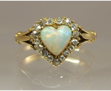 An 18ct gold opal heart and diamond ring with fleur de lys shoulders and galleried mount finger size M1/2