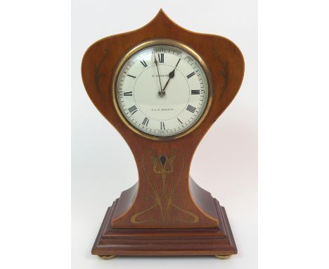 A French Art Nouveau mantle clock the mahogany case with inset stylized sinuous brass detail, upon four brass bun feet, the e