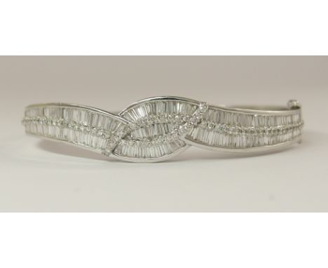 A 14ct white gold diamond set bangle set with estimated approx 3.69cts of diamonds in both brilliant cuts and baguettes. Smal