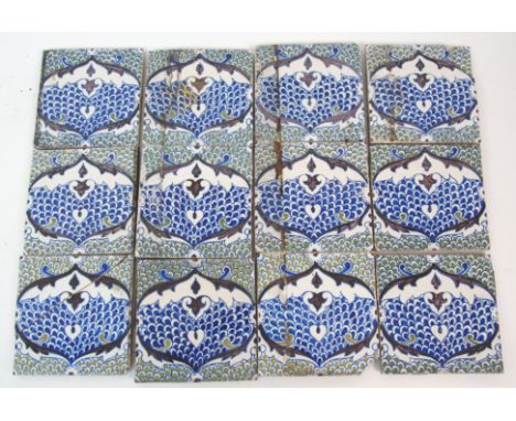 A collection of tin glazed pottery tiles with blue and brown stylised pomegranate decoration on a green and blue scale ground