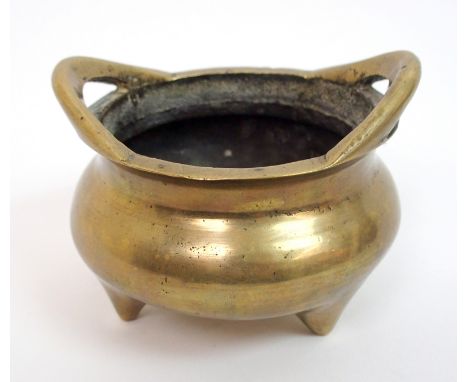 A Chinese brass two-handled censer on tripod feet cast with six character mark, 11.5cm wide