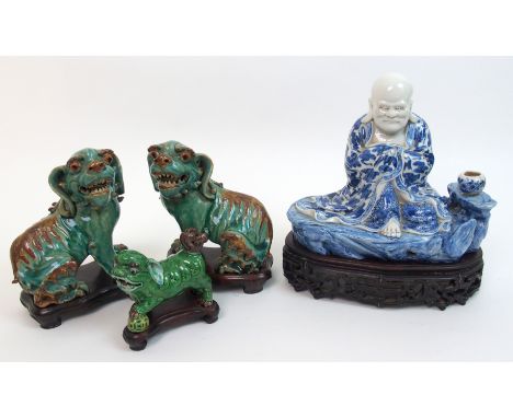 A Chinese blue and white Buddhistic figure seated on a rock wearing flowing robes with a vase at his side, impressed seal mar