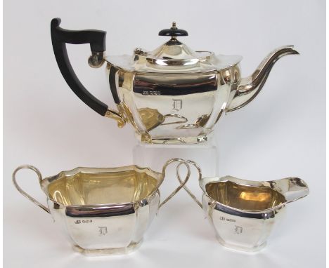 A three piece silver tea service by Robert Stewart, Sheffield 1933, of oval shape with concave canted corners on plinth base,