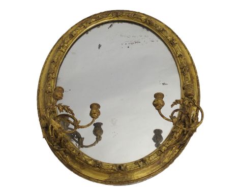 A Victorian giltwood and gesso oval wall mirror with twin candelabra, the frame applied with oak leaves and berries above the
