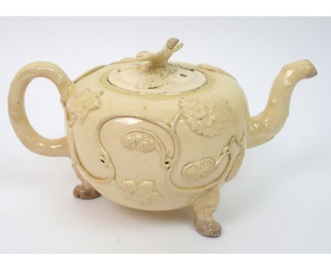 An 18th century Staffordshire creamware teapot with Crabstock handle and spout, the body with applied decoration of tendrils 
