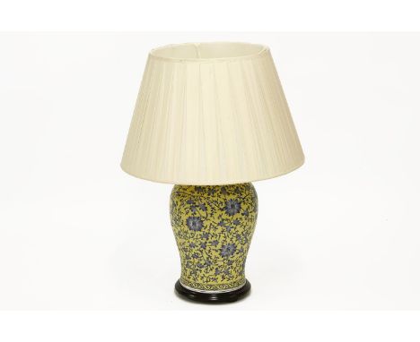 A large oriental yellow ceramic vase lamp-base with blue scrolling detail and a cream satin shade on wood plinth