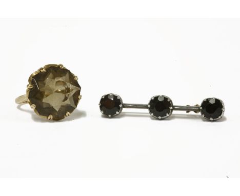 A 9ct gold single stone octagonal smokey quartz ring, together with a gold and silver three stone garnet bar brooch (tested a