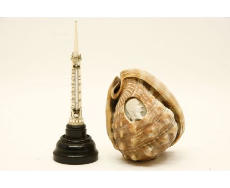 A carved sea shell, with oval cameo head, 12cm long and a Victorian carved ivory column thermometer on ebonised base. 16cm hi