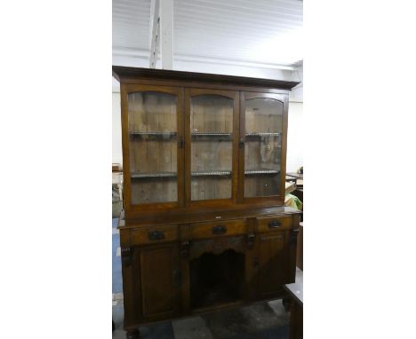 An Edwardian Oak Dresser with Glazed Shelf Top Section, Three Centre Drawers, Open Base Display Flanked by Two Panel Doors to