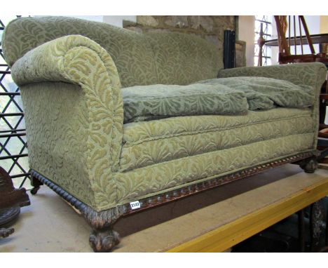 An Edwardian two seat sofa with swept and rolled arms and green coloured cut floral Mouquet patterned upholstery raised on sq