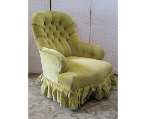 A Victorian spoon and button back low drawing room or bedroom chair, with mustard coloured upholstered finish raised on turne