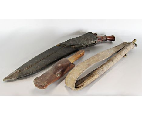 A Nepalese Kukri with two supplementary blades in a leather sheath, a simple wooden handle knife in a naive animal head sheat