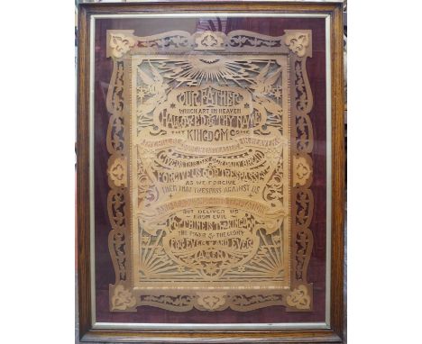 An early 20th century fretwork panel with the Lord's Prayer, mounted on velvet and in an oak moulded frame, 100 x 75cm 