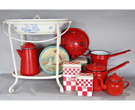 1950's red enamel kitchen utensils, storage boxes and doll's blue and white china washbasin with a divide open a metal stand.