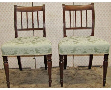 A set of six Regency mahogany dining chairs with reeded stick backs over upholstered seats raised on ring turned and tapered 