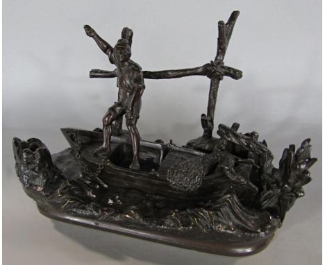 A 19th century bronze inkwell and pen holder of a fisherman standing in a rowing boat in a riverside setting, 20 cm wide x 13