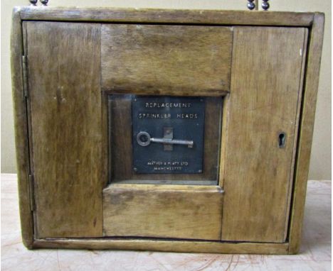 A small vintage cabinet, the centre panel enclosing a key, Replacement Sprinkler Heads by Mather &amp; Platt, Manchester, 25c