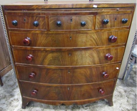 A Georgian mahogany bow fronted caddy top bedroom chest with inlaid detail and brushing slide over unusual arrangement of fou